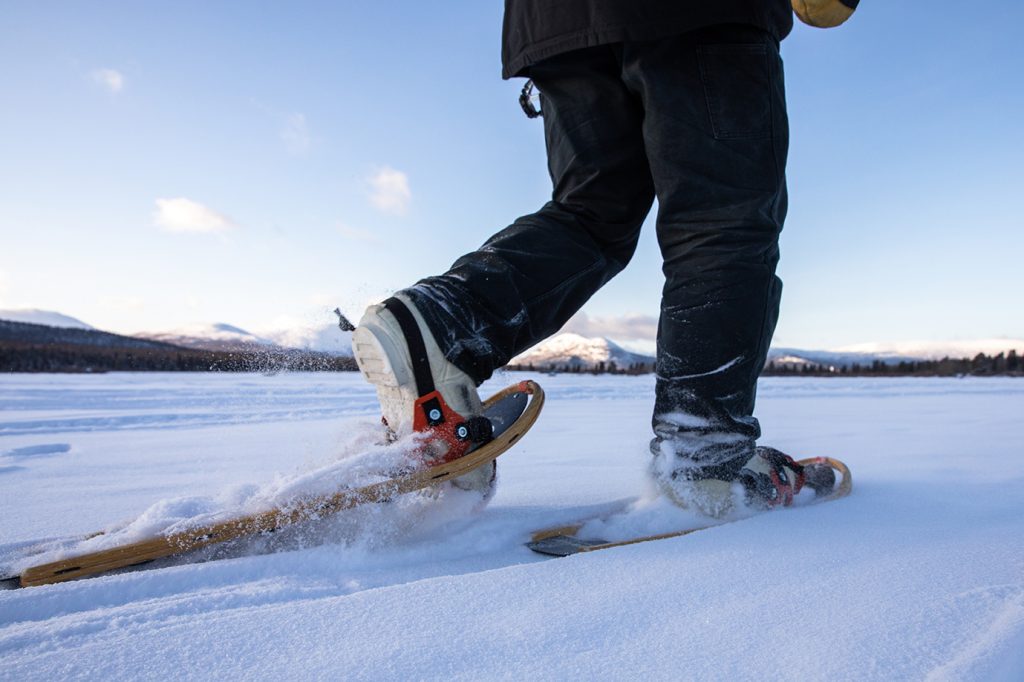Close-up of person snowshoeing through fresh powder.