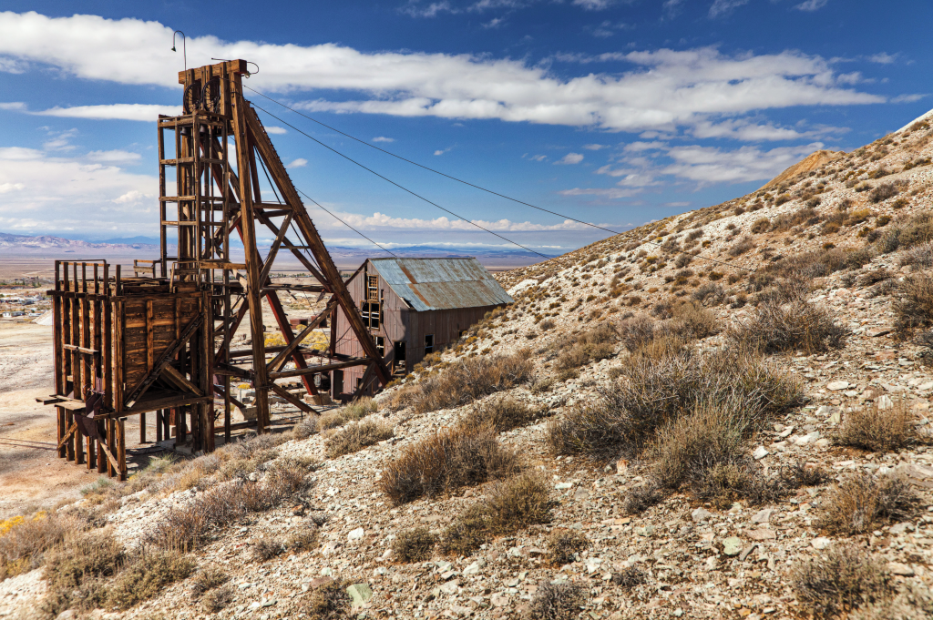 An old mine's head frame sits in a desert landscape.
